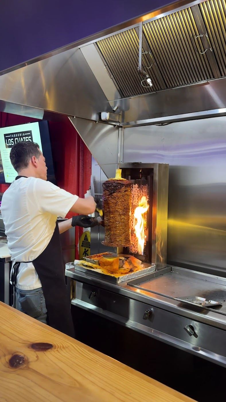Taquero carving al pastor off the trompo at Taqueria Los Cuates